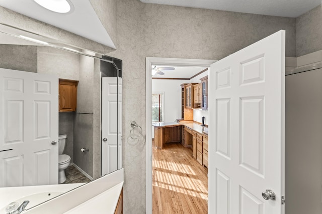 full bathroom featuring wood finished floors, vanity, toilet, and crown molding