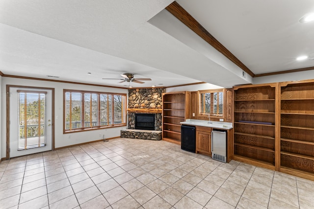 interior space featuring light tile patterned floors, a fireplace, a ceiling fan, baseboards, and crown molding