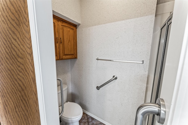 bathroom with toilet and baseboards