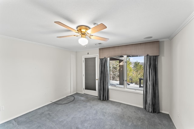 carpeted spare room featuring baseboards, a ceiling fan, and crown molding