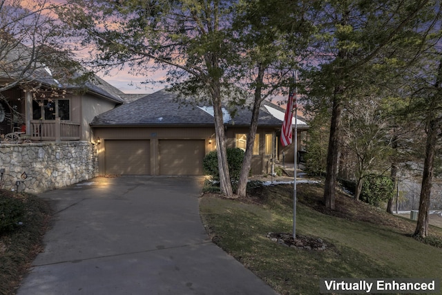 view of front of home with a garage, driveway, a shingled roof, and a front lawn