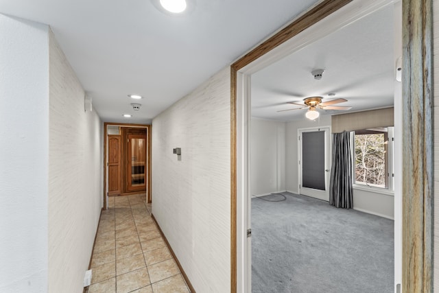 hall with light tile patterned floors and light colored carpet