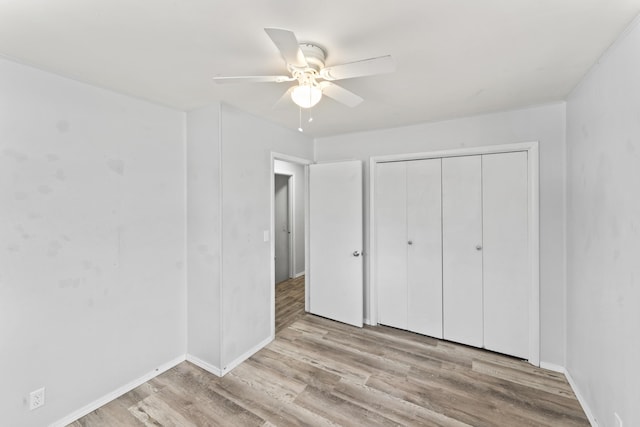 unfurnished bedroom with a closet, wood finished floors, and a ceiling fan