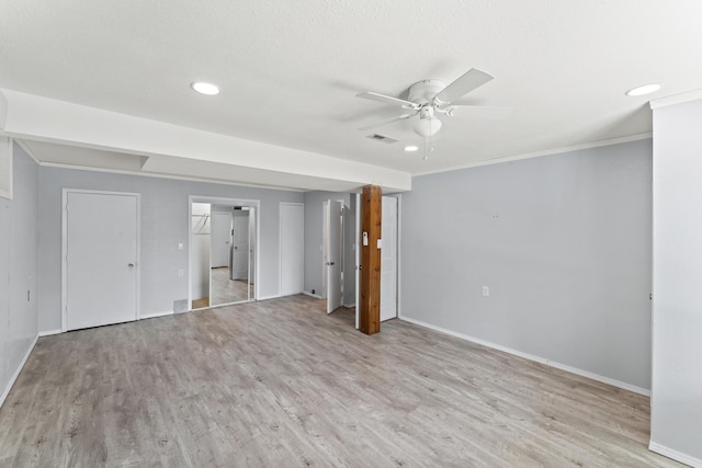 interior space featuring light wood-style floors, visible vents, ornamental molding, and baseboards