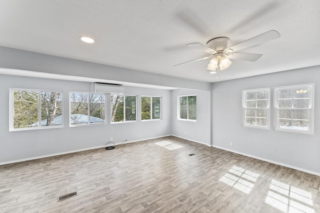 unfurnished room with a textured ceiling, wood finished floors, a ceiling fan, and baseboards