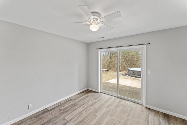 spare room with a ceiling fan, baseboards, visible vents, and wood finished floors