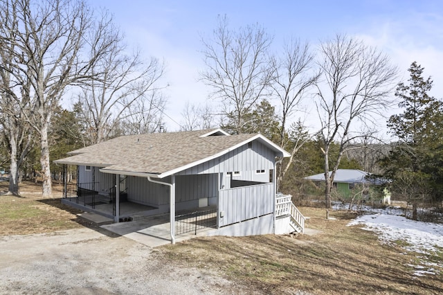 view of outdoor structure featuring dirt driveway and a carport