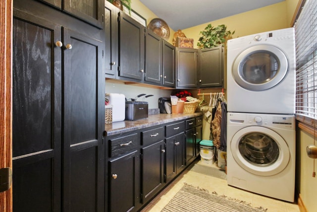 washroom featuring cabinet space, light tile patterned floors, and stacked washer / drying machine