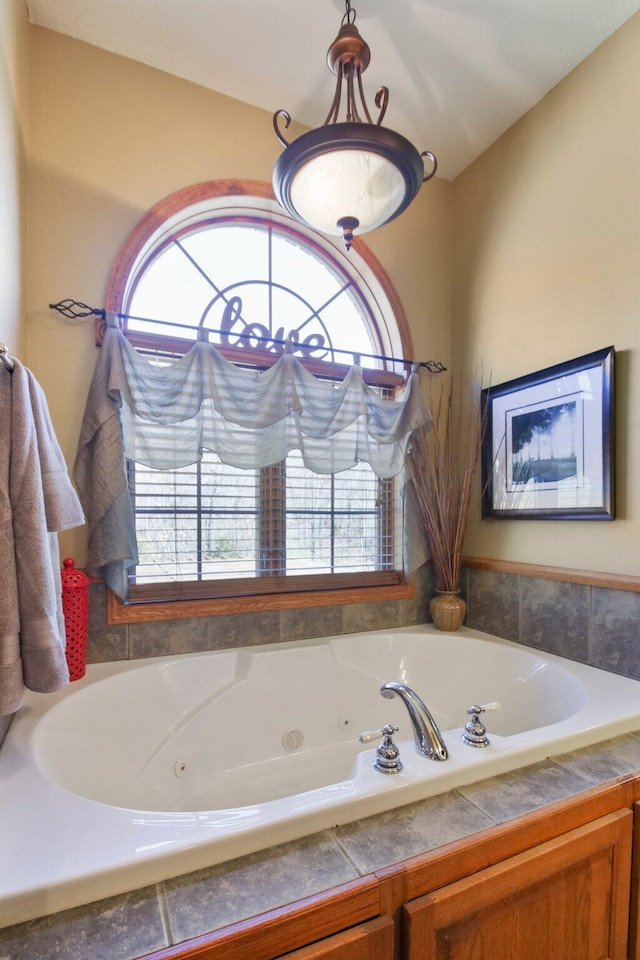 bathroom featuring a jetted tub and a healthy amount of sunlight