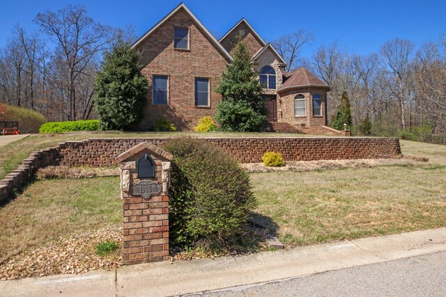 view of front of house featuring brick siding and a front lawn