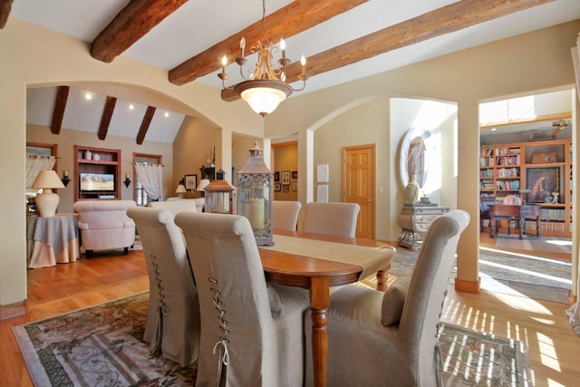 dining area featuring arched walkways, wood finished floors, a chandelier, beam ceiling, and recessed lighting