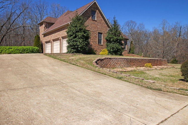 view of side of property with driveway and brick siding