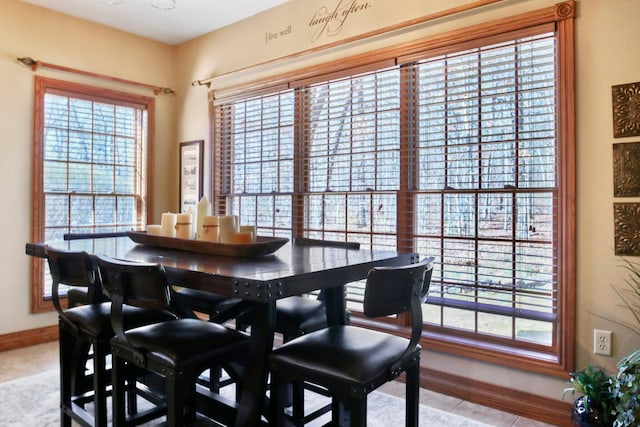 dining room with light tile patterned floors, baseboards, and a wealth of natural light