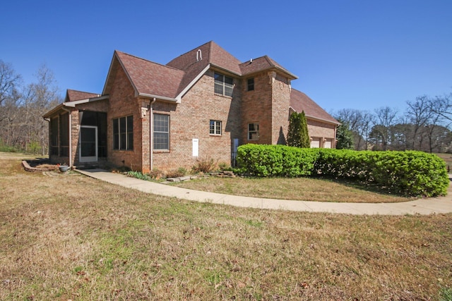 view of side of property featuring a yard, brick siding, roof with shingles, and an attached garage