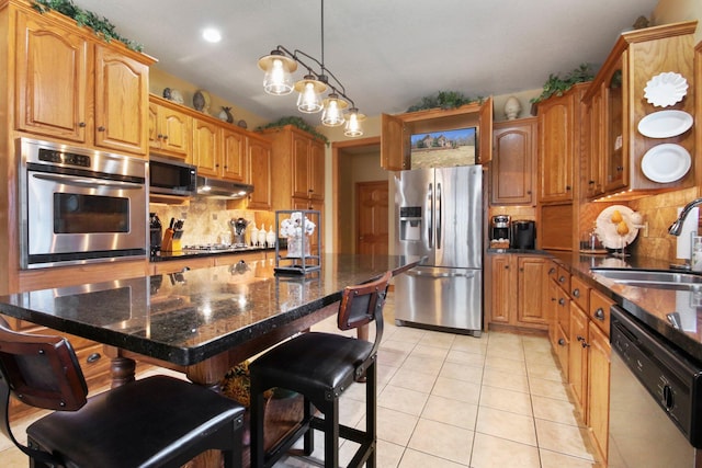 kitchen with a breakfast bar, light tile patterned floors, stainless steel appliances, and a sink