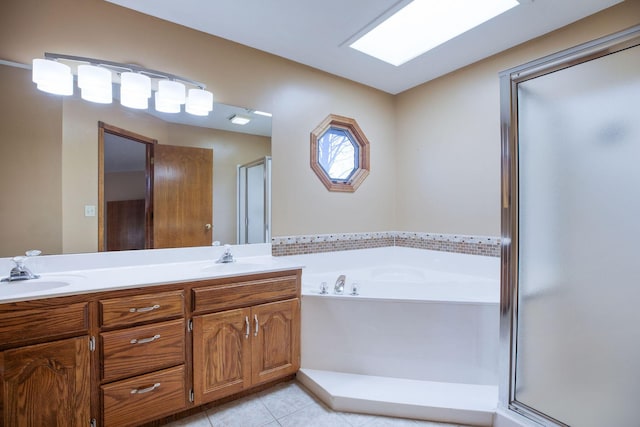 full bathroom featuring a bath, a stall shower, tile patterned flooring, and a sink