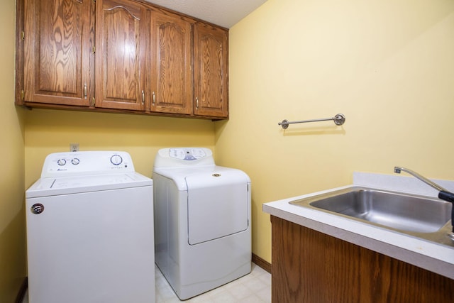 laundry area with light floors, separate washer and dryer, a sink, and cabinet space