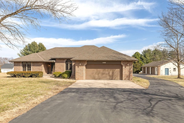 view of front of house featuring driveway, a garage, roof with shingles, a front lawn, and brick siding