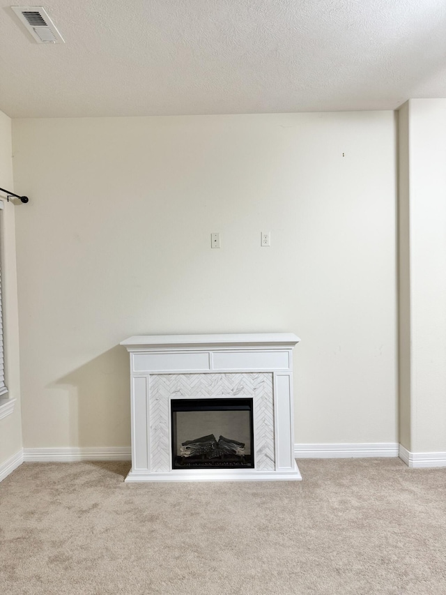 room details with carpet, visible vents, a fireplace, and a textured ceiling