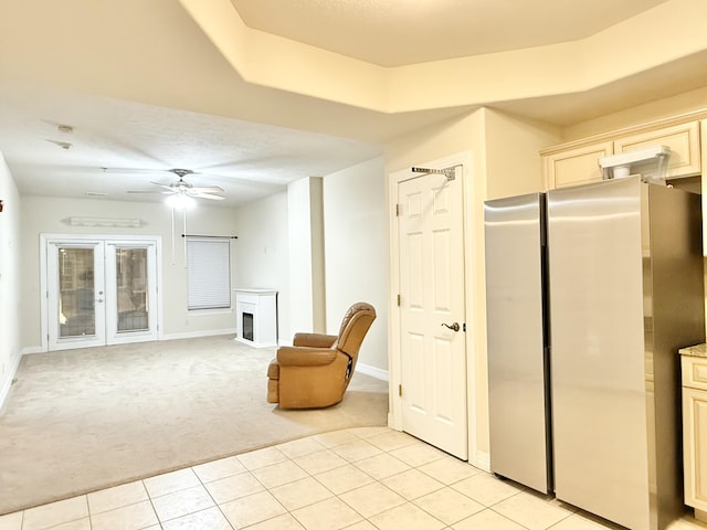 unfurnished room with baseboards, a ceiling fan, light colored carpet, french doors, and a fireplace