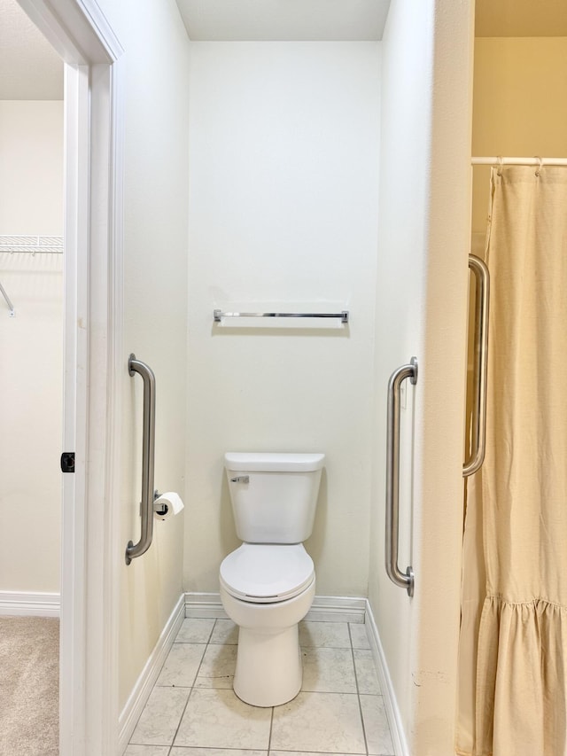 full bath featuring toilet, a shower with curtain, tile patterned flooring, and baseboards