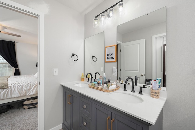 full bathroom with baseboards, a sink, ensuite bath, and double vanity