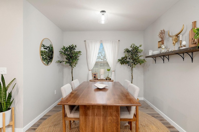 dining area with baseboards and wood finished floors