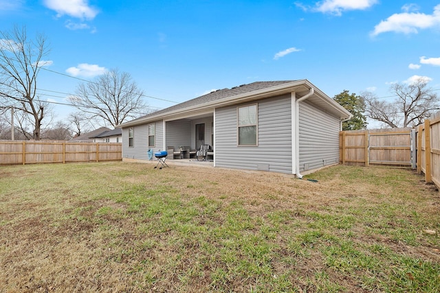 back of house with a patio area, a fenced backyard, and a lawn