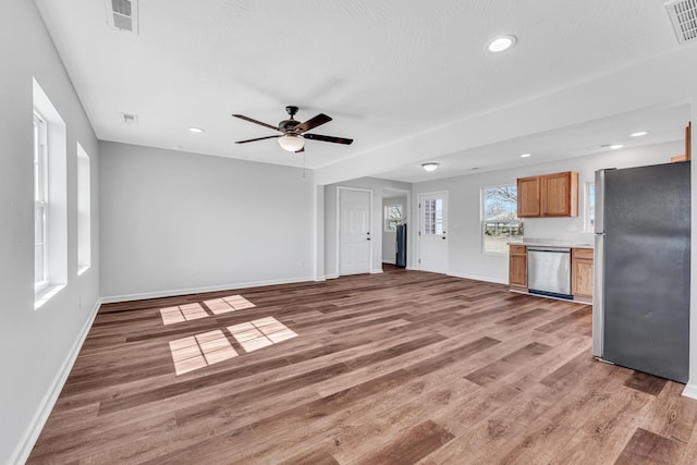 unfurnished living room with recessed lighting, light wood-type flooring, visible vents, and baseboards