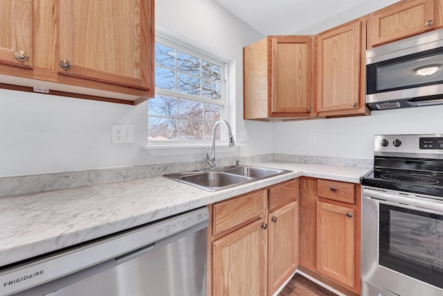 kitchen featuring light countertops, appliances with stainless steel finishes, and a sink