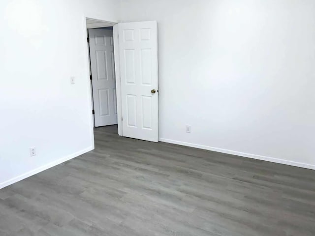 empty room with baseboards and wood finished floors