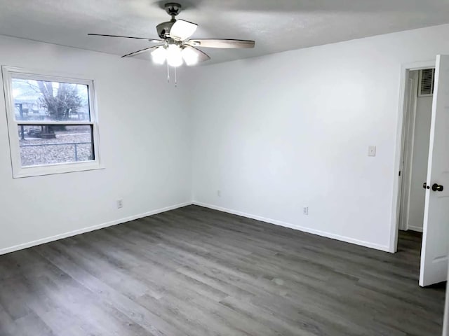 empty room with a ceiling fan, baseboards, and dark wood-type flooring