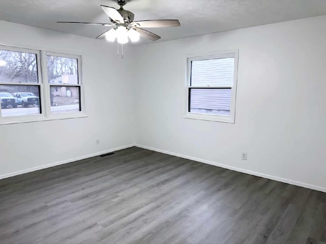 unfurnished room with visible vents, baseboards, a ceiling fan, wood finished floors, and a textured ceiling