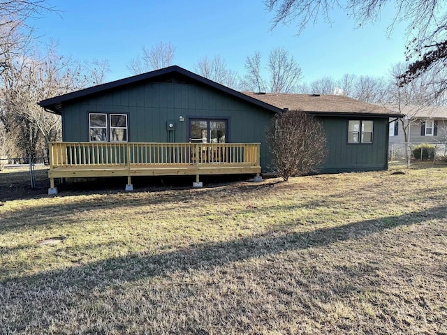 exterior space with a deck, a front lawn, and fence