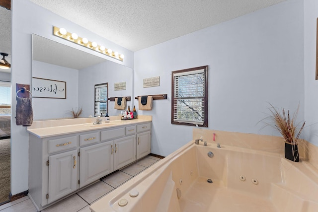 bathroom featuring a textured ceiling, a jetted tub, tile patterned flooring, and vanity