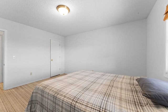 bedroom featuring baseboards and a textured ceiling