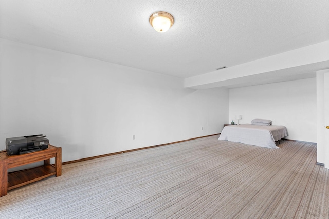 bedroom with carpet flooring, visible vents, baseboards, and a textured ceiling