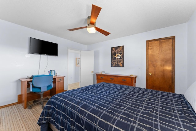 bedroom featuring a ceiling fan, light carpet, a textured ceiling, and baseboards