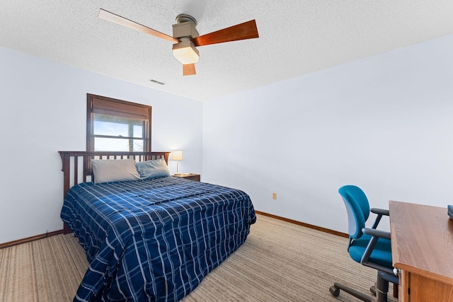 carpeted bedroom with a textured ceiling, ceiling fan, visible vents, and baseboards