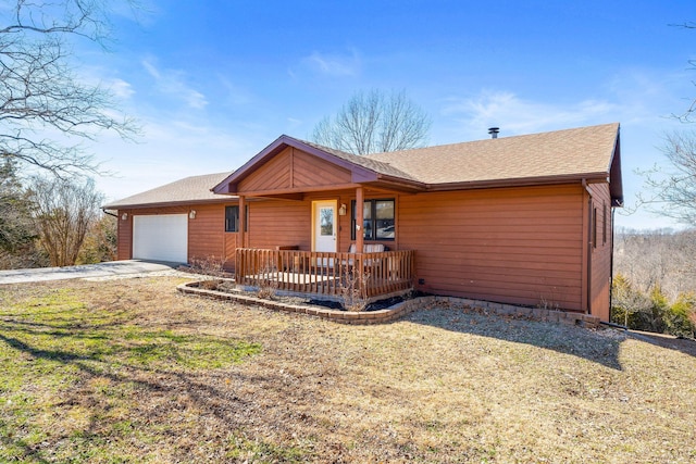 view of front of property featuring a garage and roof with shingles