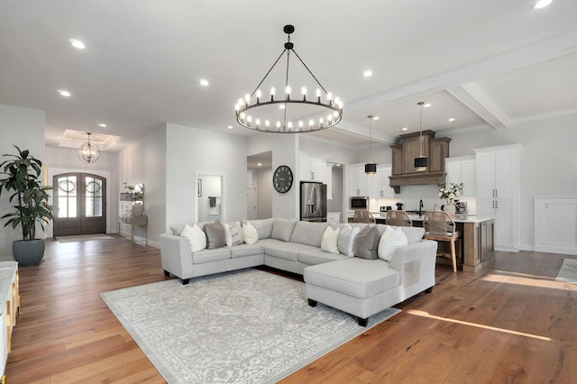 living area featuring recessed lighting, baseboards, french doors, light wood finished floors, and an inviting chandelier