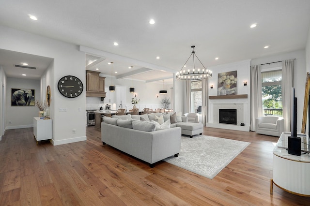 living area with recessed lighting, a large fireplace, wood finished floors, visible vents, and baseboards