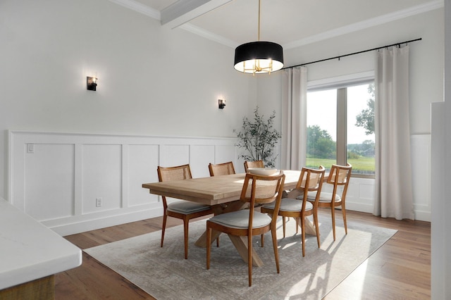 dining area with wainscoting, crown molding, beamed ceiling, and light wood finished floors