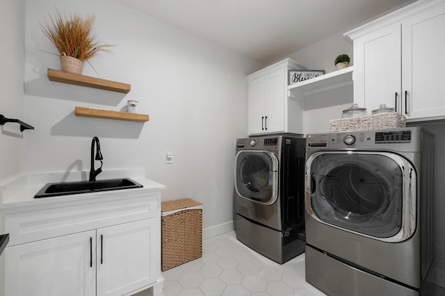 washroom with washer and dryer, cabinet space, a sink, and baseboards