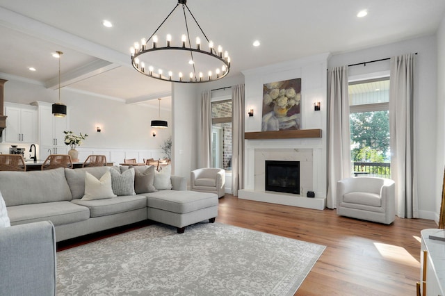 living room with recessed lighting, a premium fireplace, wood finished floors, beam ceiling, and crown molding