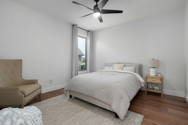 bedroom with ceiling fan, baseboards, and wood finished floors