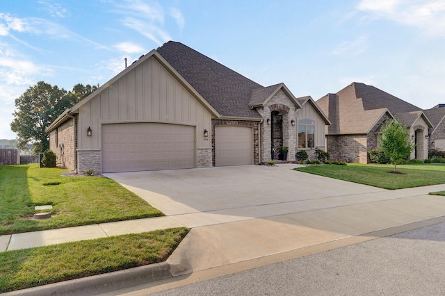 view of front of home with an attached garage, stone siding, board and batten siding, and a front yard