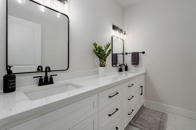 full bath featuring double vanity, baseboards, and a sink