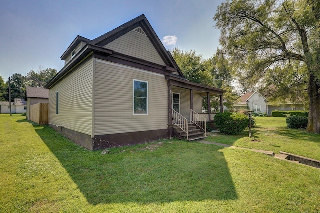 back of property featuring covered porch and a lawn