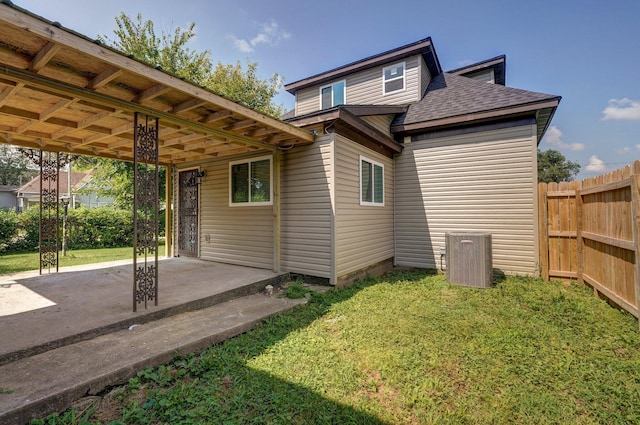 rear view of property featuring a yard, a patio, fence, an attached carport, and driveway